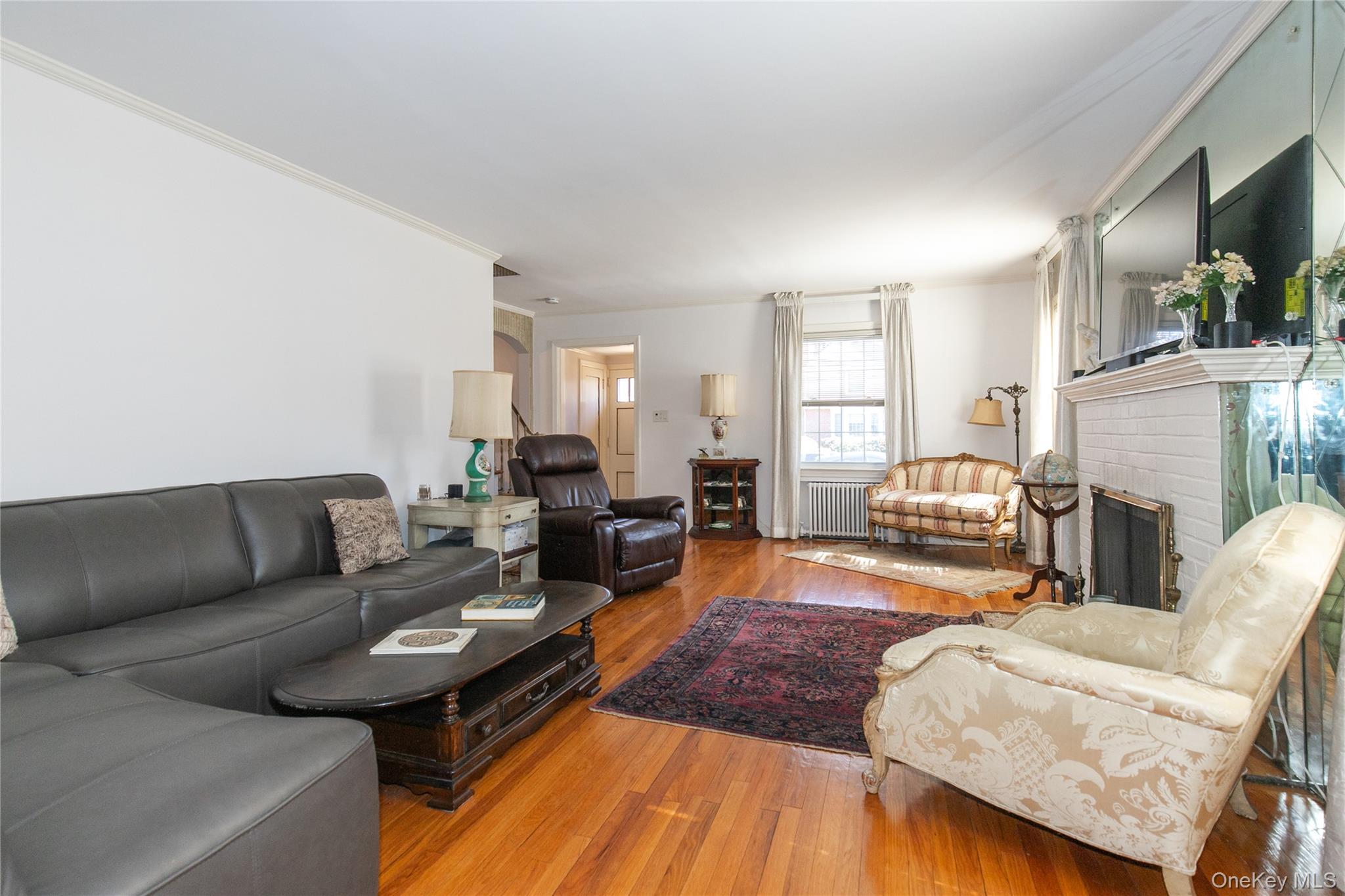 8 Plymouth Road Great Neck, NY 11023 - Photo 4 of 25 a living room with furniture fireplace and flat screen tv