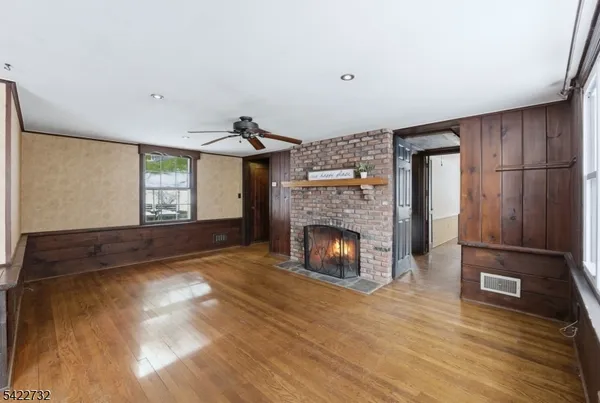 a view of empty room with wooden floor and fireplace