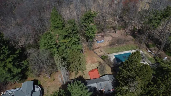an aerial view of a house with plants and large trees