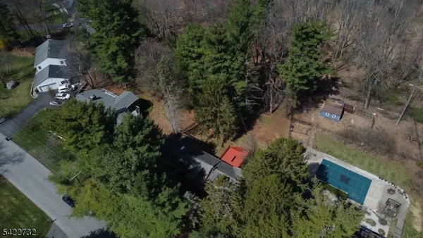 an aerial view of residential house with outdoor space and trees all around