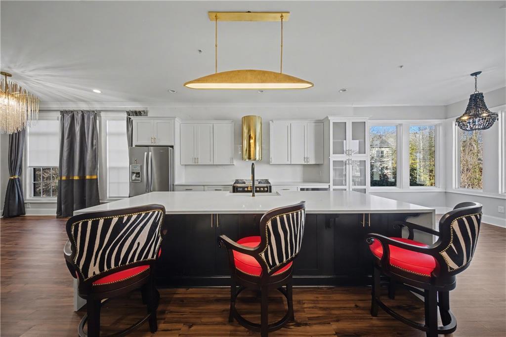 2067 Wheaton Way Atlanta, GA 30328 - Photo 26 of 64 a kitchen with stainless steel appliances granite countertop a dining table chairs and a refrigerator
