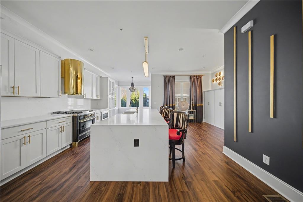2067 Wheaton Way Atlanta, GA 30328 - Photo 32 of 64 a kitchen with a wooden floor and white cabinets