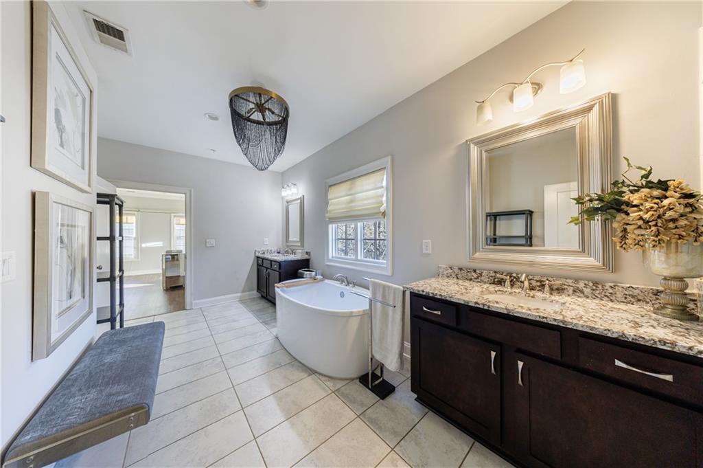 2067 Wheaton Way Atlanta, GA 30328 - Photo 44 of 64 a spacious bathroom with a granite countertop sink and a mirror