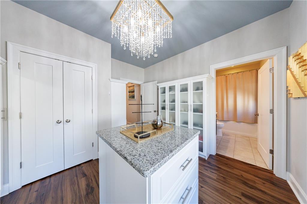 2067 Wheaton Way Atlanta, GA 30328 - Photo 46 of 64 a kitchen with granite countertop wooden floor and a refrigerator