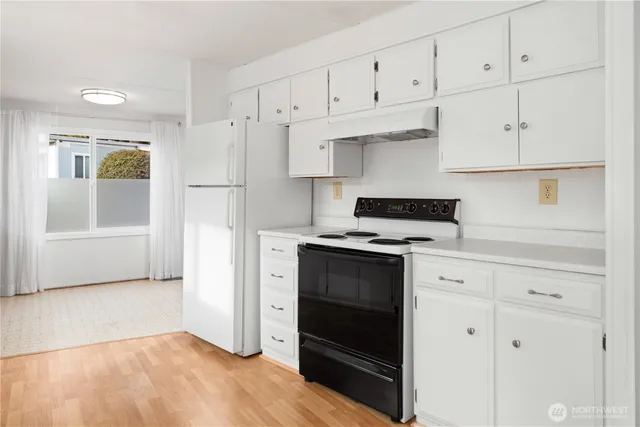 a kitchen with granite countertop white cabinets and stainless steel appliances