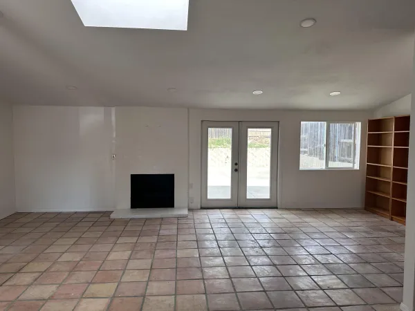 a view of an empty room with window and cabinet