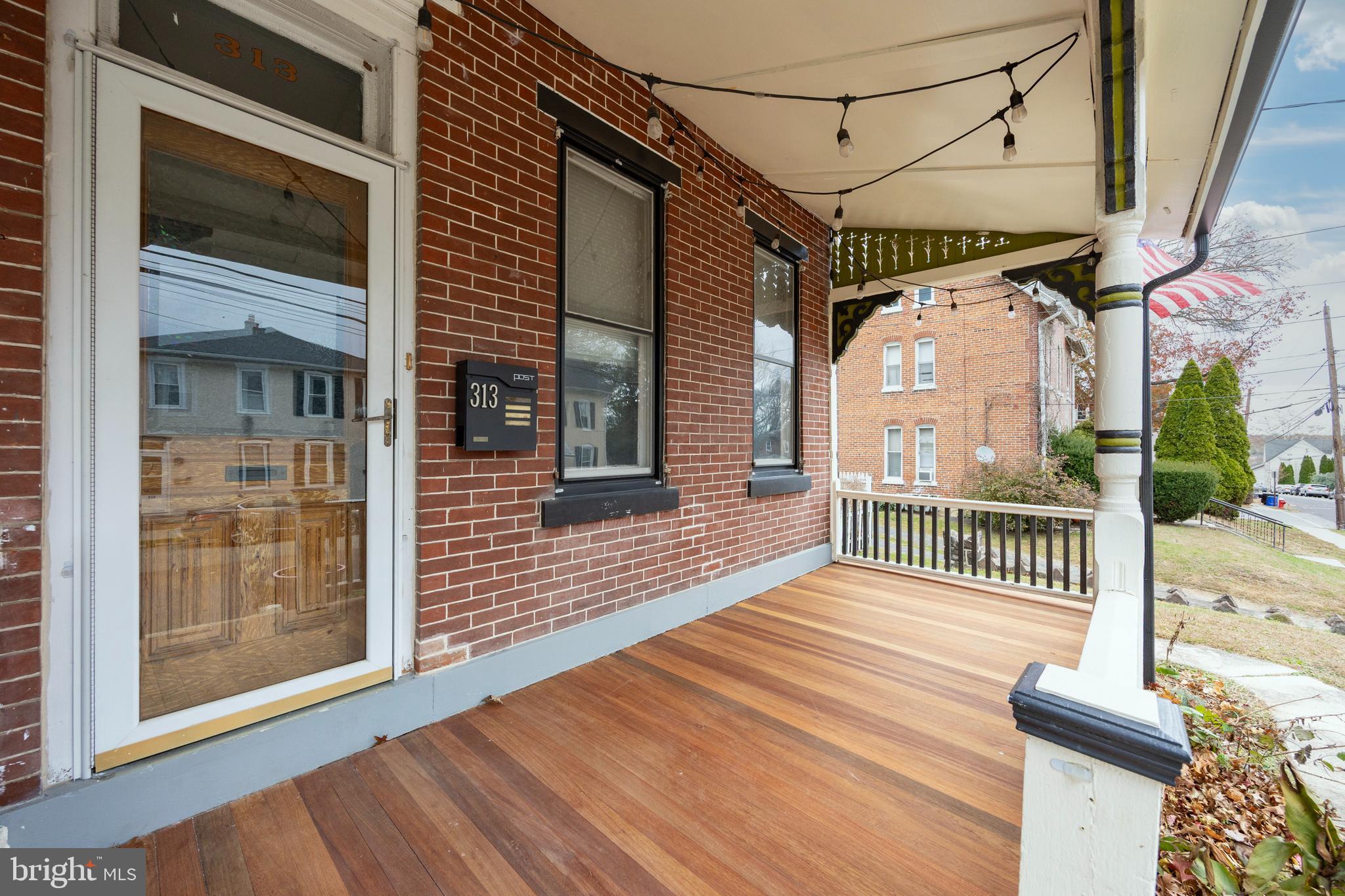 a view of a porch with wooden floor and iron stairs