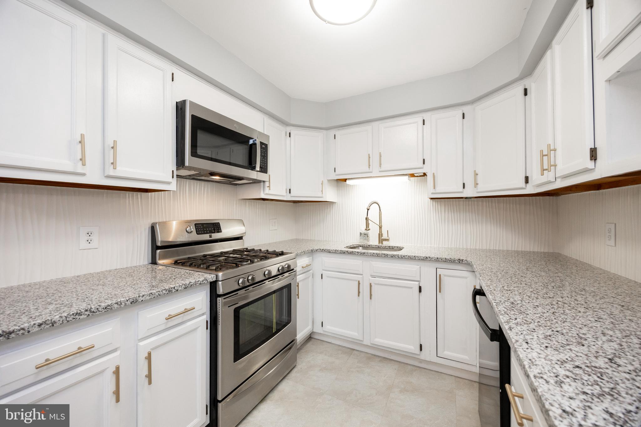 313 Chestnut Street Spring City, PA 19475 - Photo 11 of 38 a kitchen with stainless steel appliances granite countertop a sink a stove and microwave