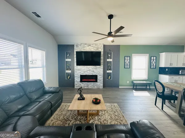 a living room with furniture a fireplace and a flat screen tv