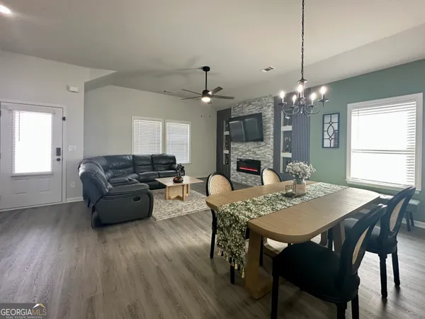 a living room with furniture dining table and a chandelier