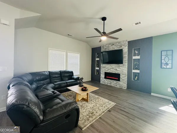 a living room with furniture a fireplace and a flat screen tv