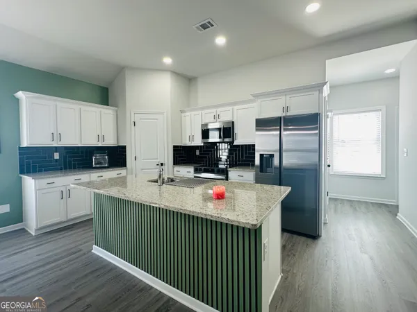 a kitchen that has a lot of cabinets and wooden floor