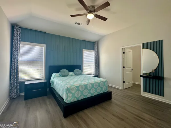 a bedroom with a bed dresser and a window