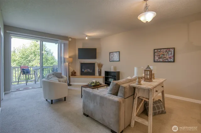 a living room with furniture a fireplace and a floor to ceiling window