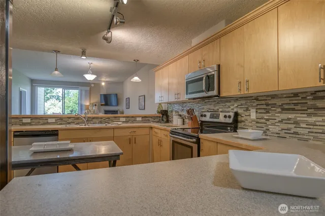 a kitchen with stainless steel appliances granite countertop a stove a sink and a microwave
