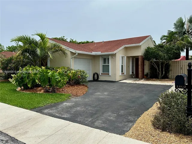 a front view of a house with a yard and potted plants