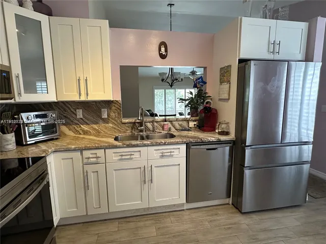 a kitchen with a refrigerator sink and cabinets