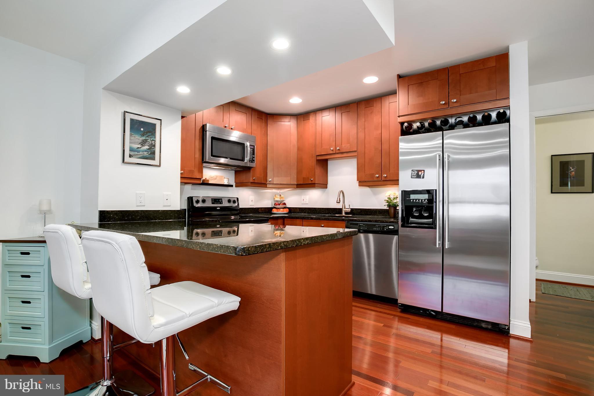 1119 Harvard Street Northwest, Unit R Washington, DC 20009 - Photo 11 of 26 a kitchen with kitchen island a counter top space cabinets and stainless steel appliances
