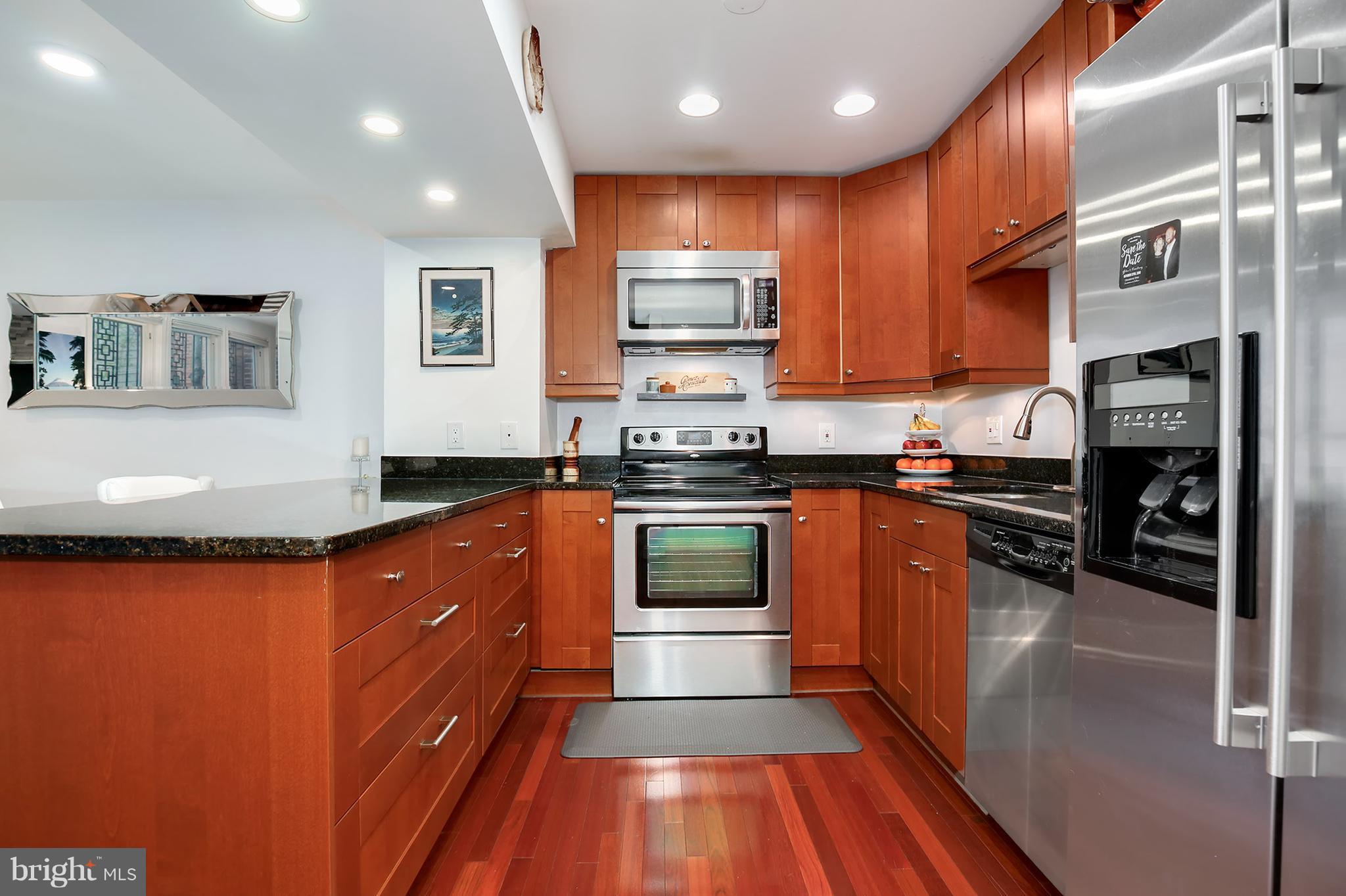 1119 Harvard Street Northwest, Unit R Washington, DC 20009 - Photo 12 of 26 a kitchen with stainless steel appliances granite countertop wooden cabinets a stove top oven a sink and dishwasher