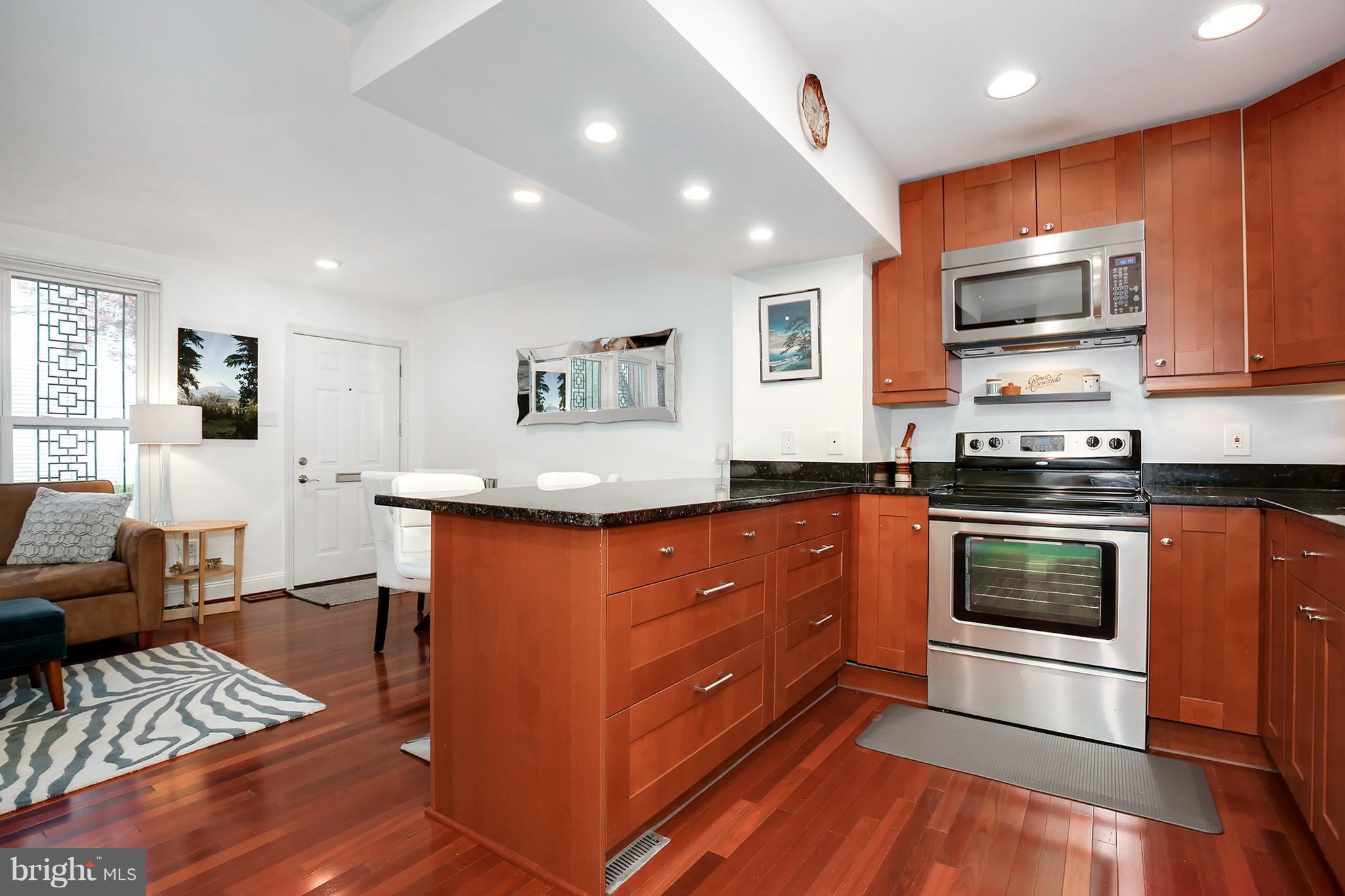 1119 Harvard Street Northwest, Unit R Washington, DC 20009 - Photo 13 of 26 a kitchen with stainless steel appliances granite countertop a stove a sink and a microwave