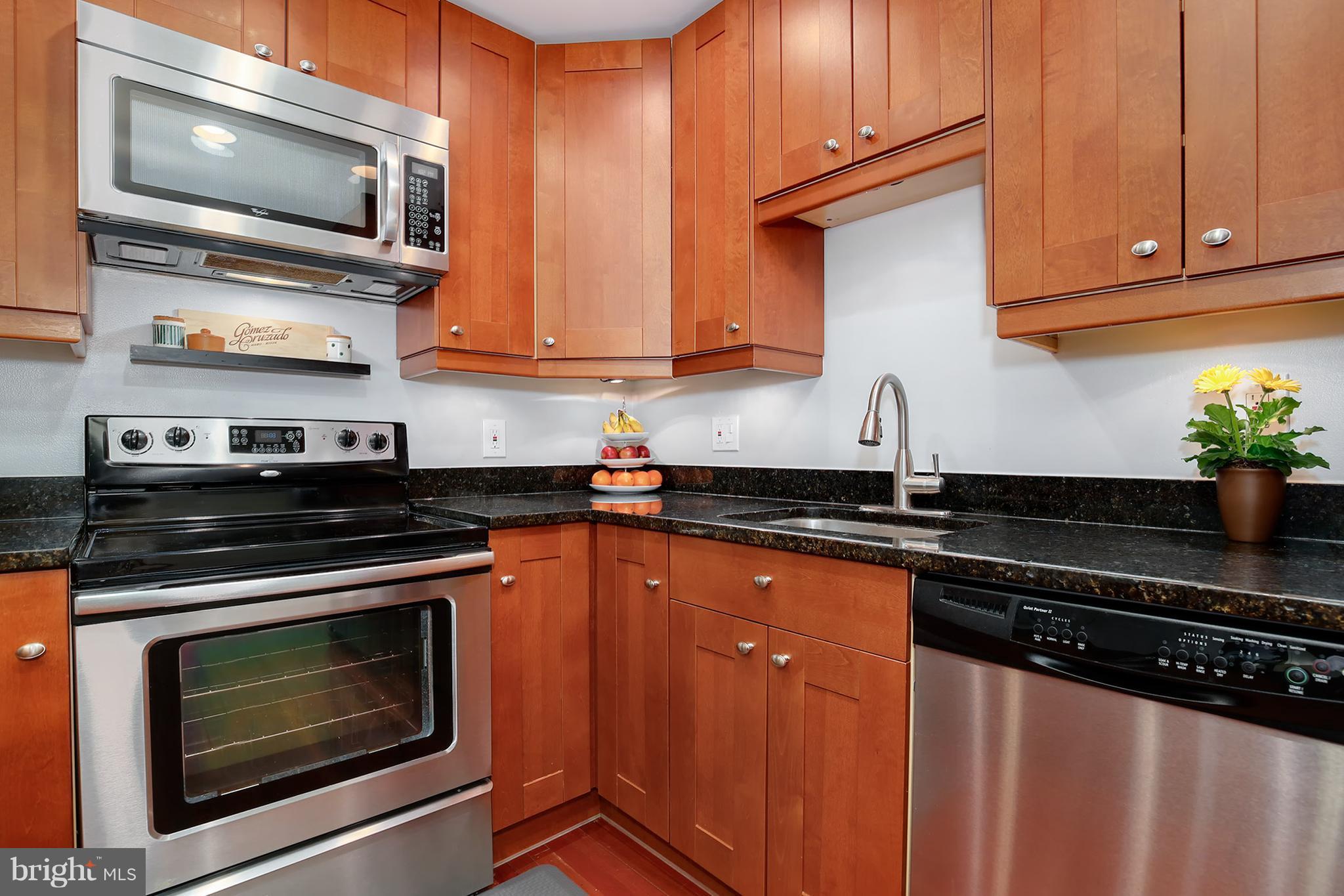 1119 Harvard Street Northwest, Unit R Washington, DC 20009 - Photo 14 of 26 a kitchen with stainless steel appliances granite countertop a stove microwave and cabinets