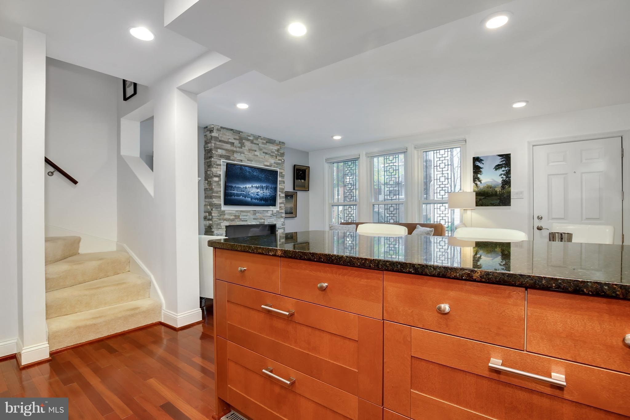 1119 Harvard Street Northwest, Unit R Washington, DC 20009 - Photo 15 of 26 a kitchen with granite countertop cabinets stainless steel appliances a sink and a counter top space