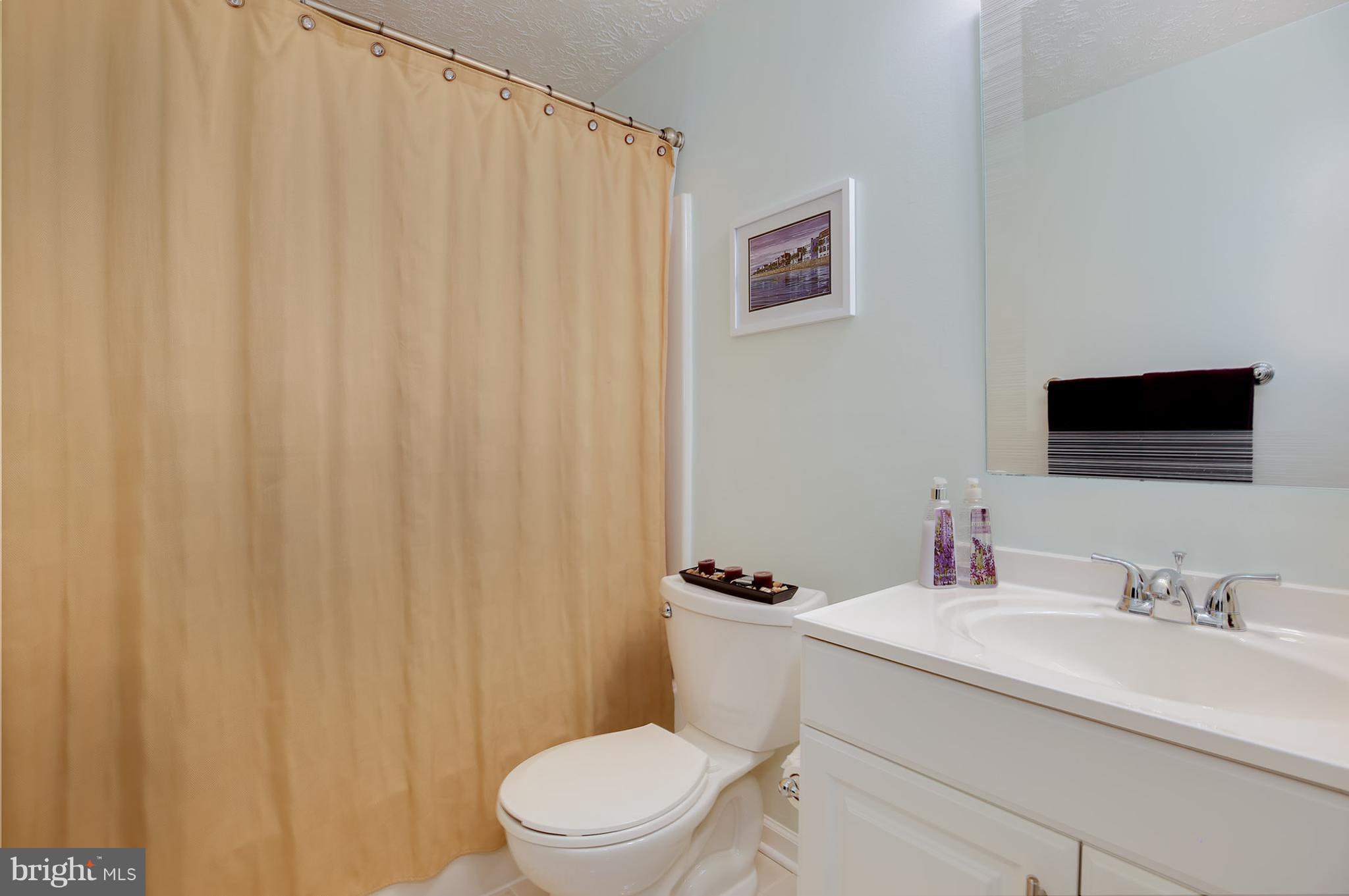 1119 Harvard Street Northwest, Unit R Washington, DC 20009 - Photo 25 of 26 a bathroom with a sink a toilet and a mirror