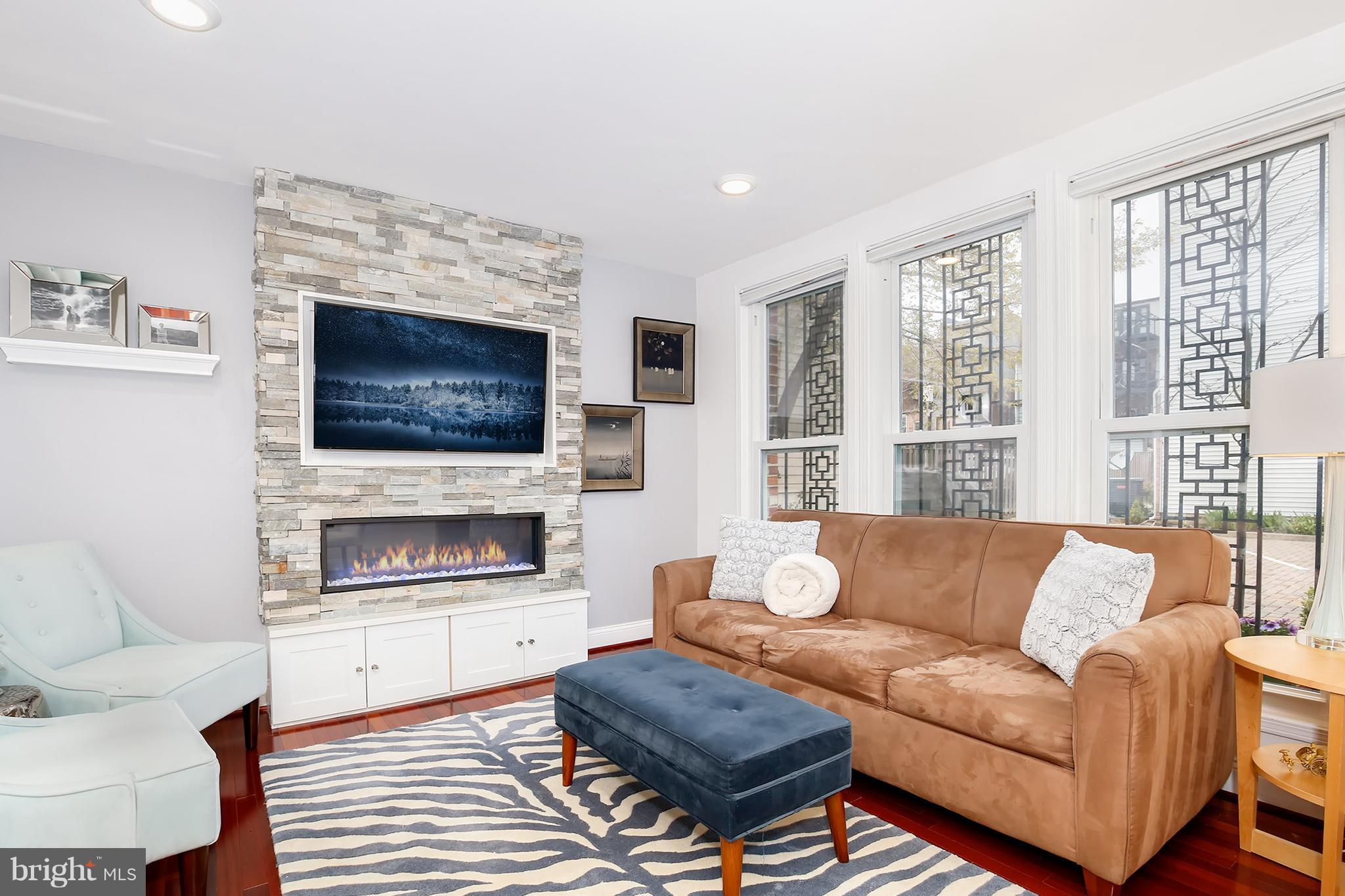 1119 Harvard Street Northwest, Unit R Washington, DC 20009 - Photo 4 of 26 a living room with furniture flat screen tv and a fireplace