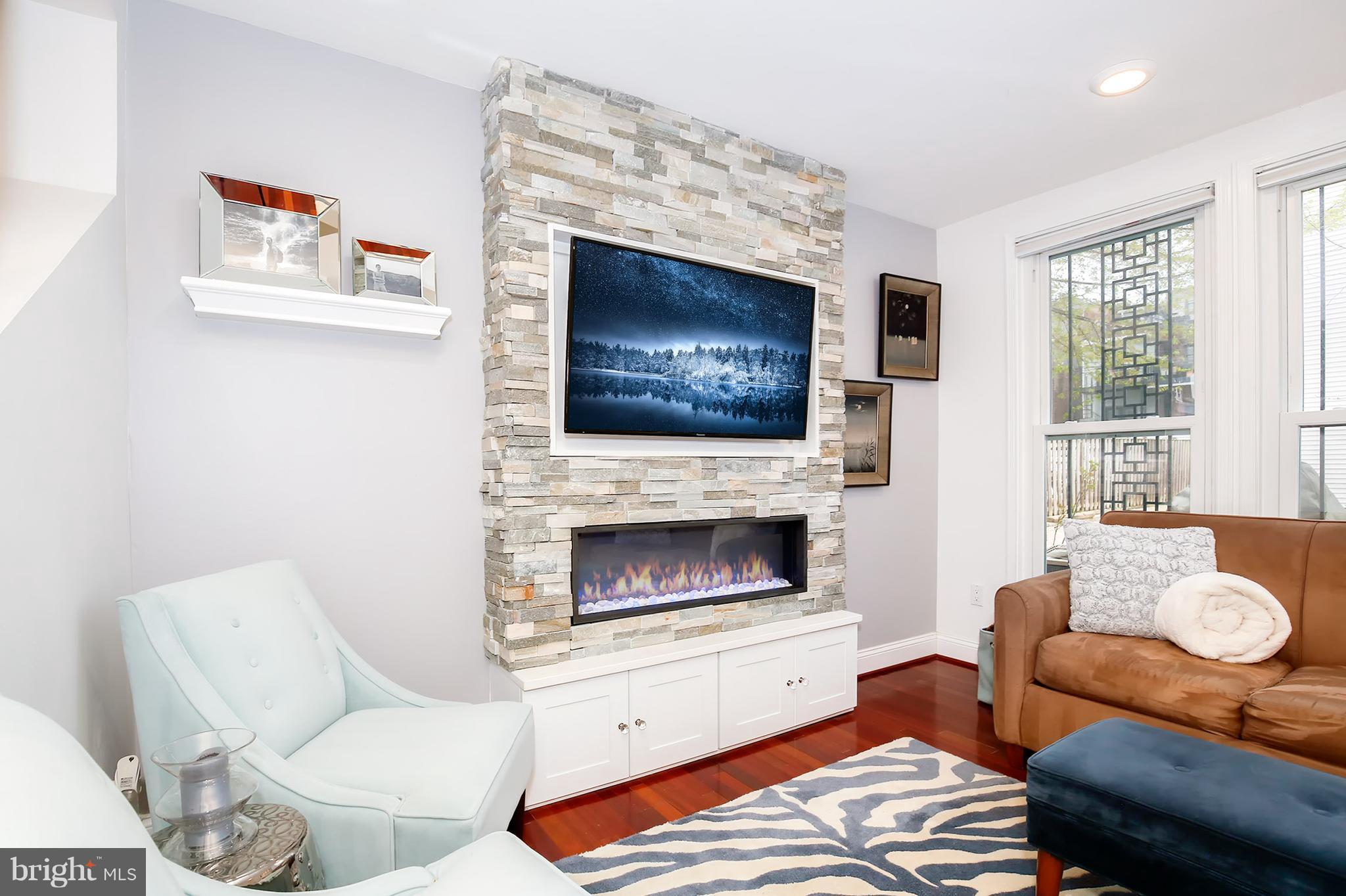 1119 Harvard Street Northwest, Unit R Washington, DC 20009 - Photo 6 of 26 a living room with furniture a flat screen tv and a fireplace