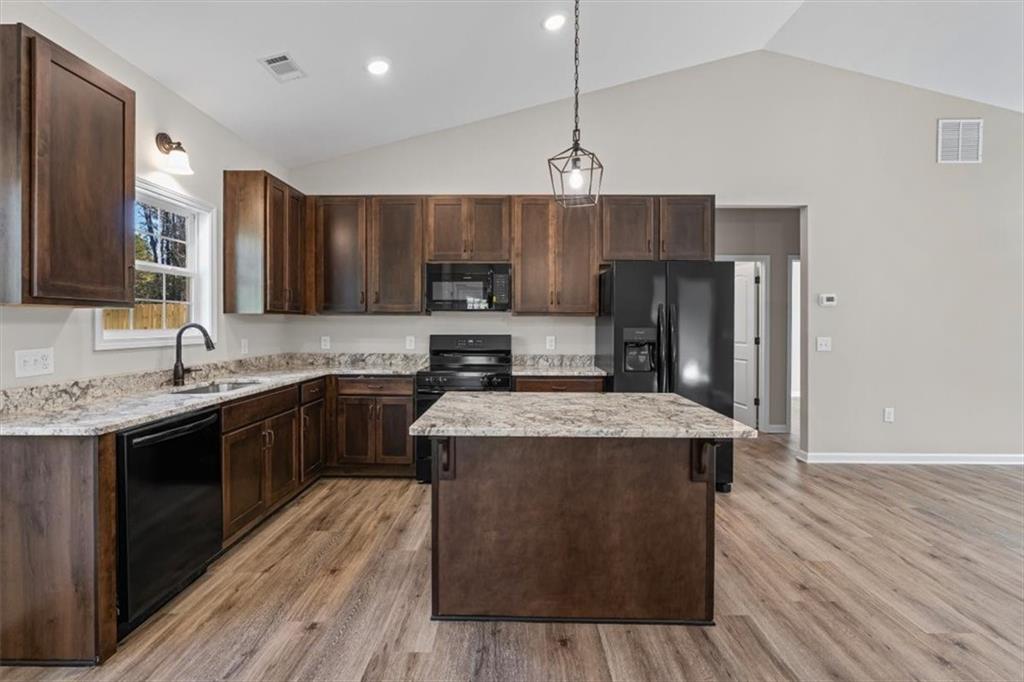 146 Old Brock Road Rockmart, GA 30153 - Photo 17 of 45 a kitchen with kitchen island granite countertop wooden floors stainless steel appliances a sink and a center island