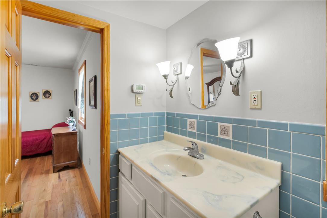 3915 Hecktown Road Bethlehem, PA 18020 - Photo 27 of 42 Classic ceramic tile wainscoting and a molded vanity top define this character-filled washroom.