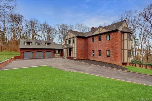 a front view of a house with a yard and trees