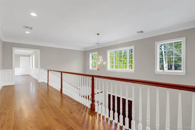 a view of empty room with wooden floor and ceiling fan
