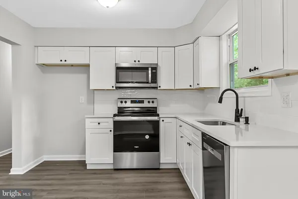a kitchen with stainless steel appliances a stove microwave and sink