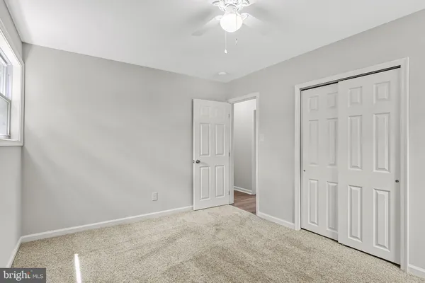 an empty room with a ceiling fan and a window