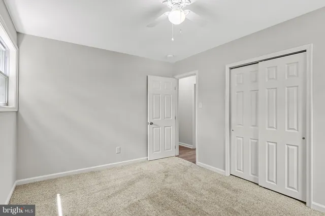 an empty room with a ceiling fan and a window