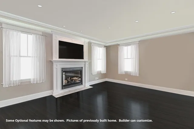 an empty room with wooden floor fireplace and windows