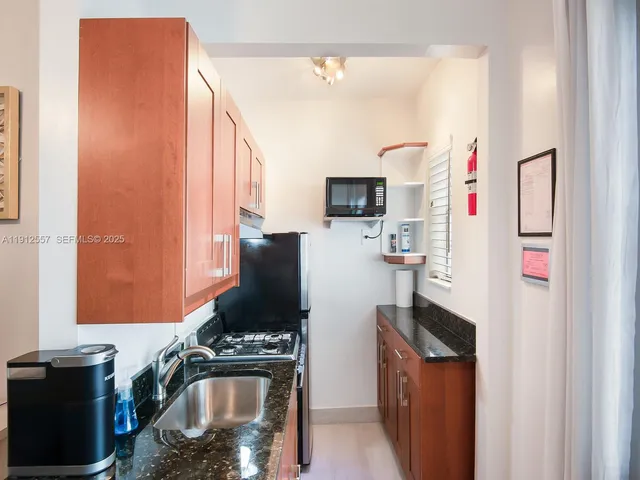 a kitchen with stainless steel appliances stove top oven refrigerator and cabinets