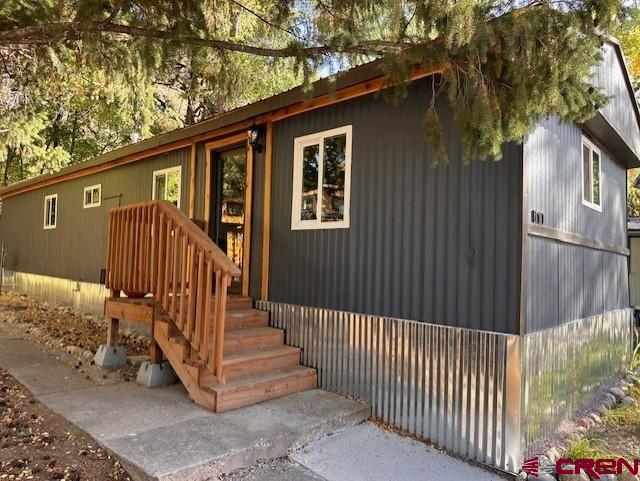 a view of a house with a small yard and wooden fence and floor to ceiling window