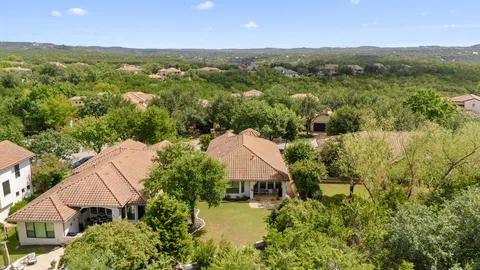 a front view of a house with a yard and large trees