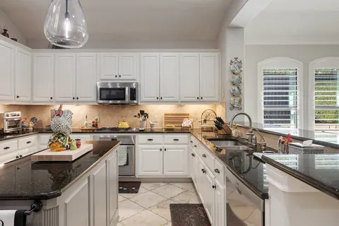 a kitchen with stainless steel appliances granite countertop a sink stove and cabinets