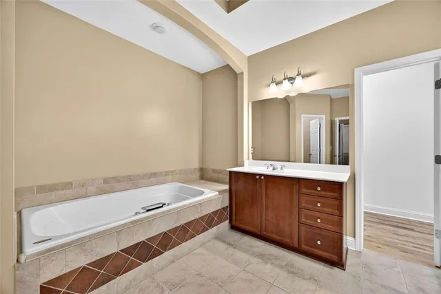 a bathroom with a tub sink and mirror