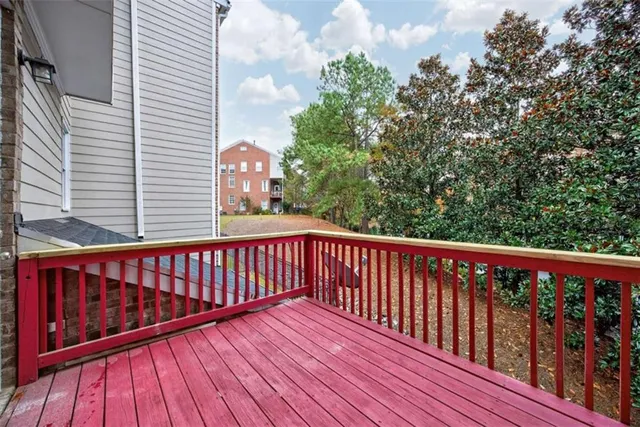 a balcony with wooden floor and trees in the back