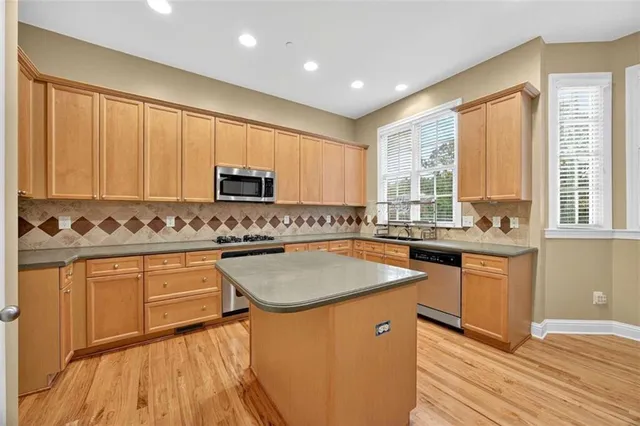a kitchen with stainless steel appliances granite countertop sink stove top oven and cabinets