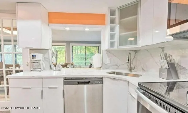 a kitchen with kitchen island granite countertop a sink and a stove top oven