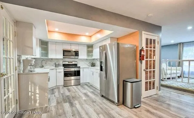 a kitchen with stainless steel appliances a refrigerator stove and microwave