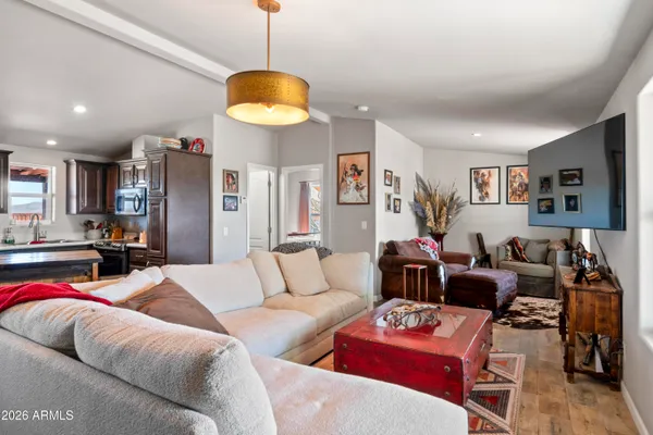 a kitchen with stainless steel appliances granite countertop a stove refrigerator and a dining table with wooden floor