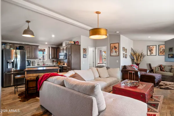 a kitchen with stainless steel appliances kitchen island granite countertop a table chairs in it and a window
