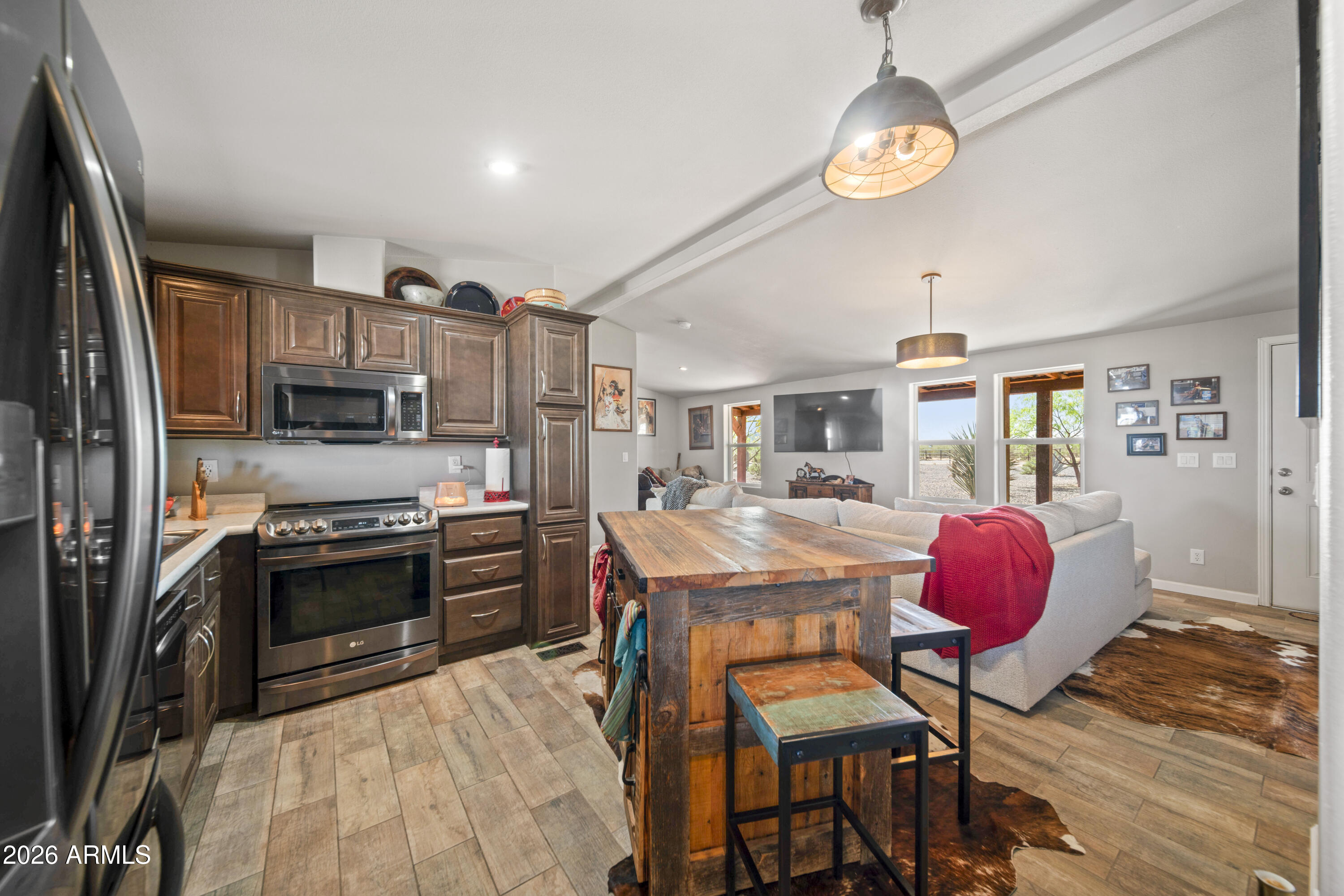52510 Williams Road Aguila, AZ 85320 - Photo 22 of 62 a kitchen with stainless steel appliances granite countertop a stove refrigerator and a dining table with wooden floor