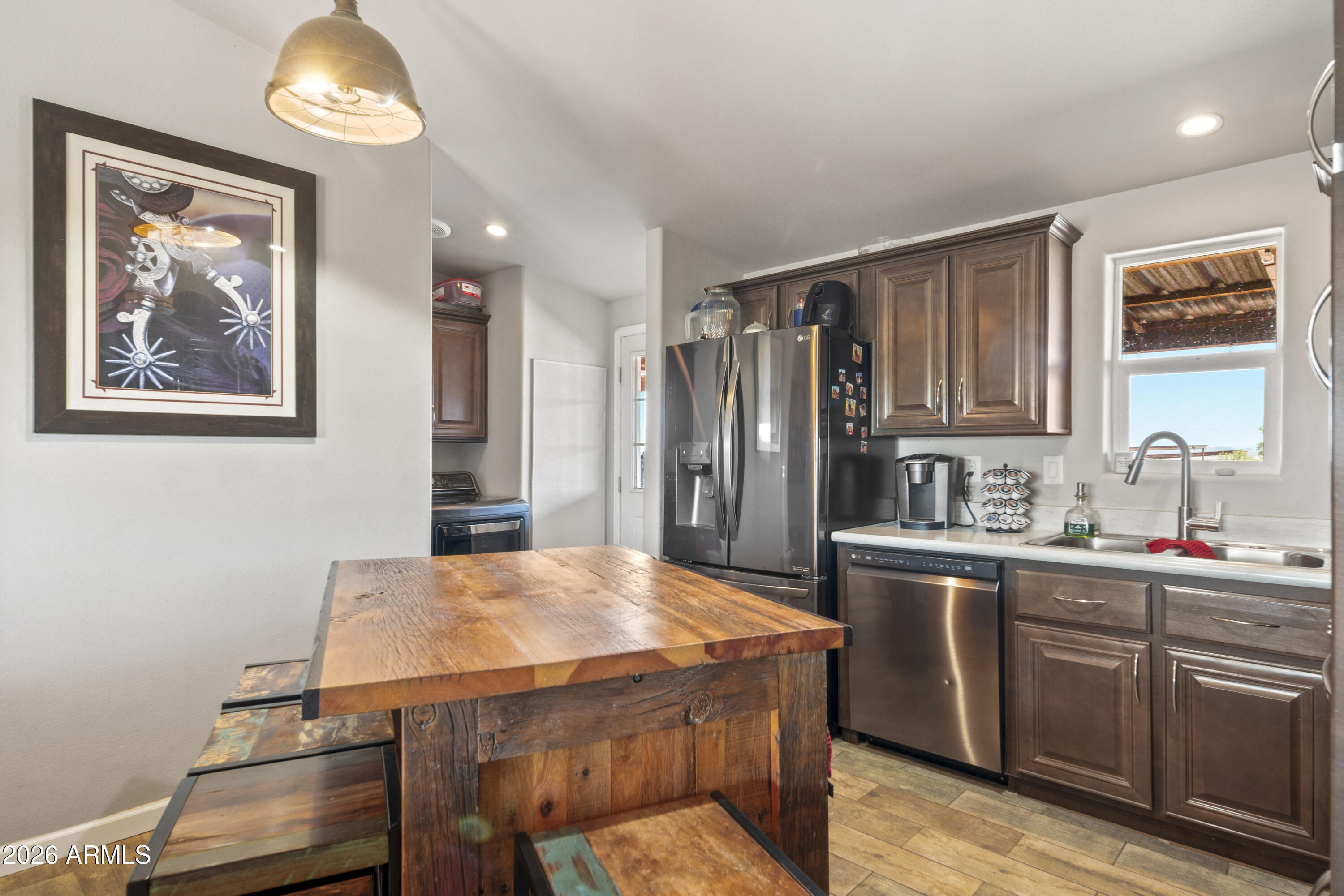 52510 Williams Road Aguila, AZ 85320 - Photo 25 of 62 a kitchen with stainless steel appliances a table and chairs in it